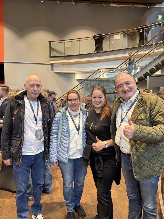 Vier Personen beim gemeinsamen Gruppenfoto auf dem AJAX-Event